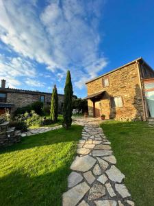 a stone house with a stone path in the yard at Complejo Rural Lar de Vies in A Pontenova