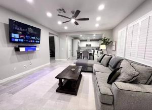 ein Wohnzimmer mit einem Sofa und einem TV in der Unterkunft San Diego Luxury Oasis in Spring Valley