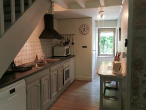 a kitchen with a sink and a microwave at L'Enclose in Davignac