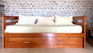 Cama de madera con sábanas y almohadas blancas en Las Marías en Azcuénaga