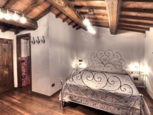 una camera con letto in metallo in una stanza con soffitti in legno di La Locanda di Giulia ad Arezzo