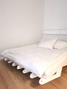 a white bed with white sheets and pillows at Studios des Arcades in La Neuveville +18 photos