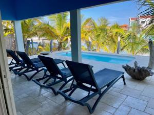 a row of chairs sitting next to a swimming pool at Caribbean Lofts Bonaire in Kralendijk