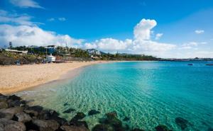 a view of a beach with blue water and rocks at Apartamento Playa Blanca in Playa Blanca