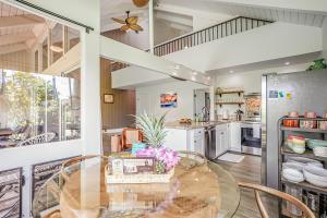 a large kitchen with a glass table and chairs at Pali Ke Kua #4 in Princeville