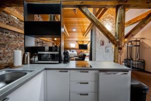 a kitchen with white cabinets and a brick wall at Vintage Industrial City Apartments in Košice