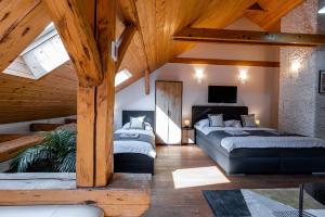 a attic bedroom with two beds and a tv at Vintage Industrial City Apartments in Košice