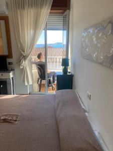a woman sitting in a chair in a room with a window at Hotel L'Ancora in La Caletta