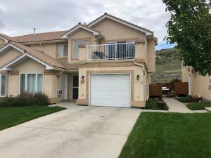 uma casa com uma porta de garagem branca num quintal em Paradise Canyon Golf Resort - Luxury Condo M399 em Lethbridge