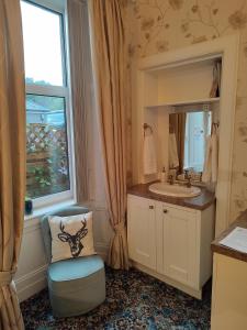 a bathroom with a sink and a mirror at Dunallan Guest House in Perth