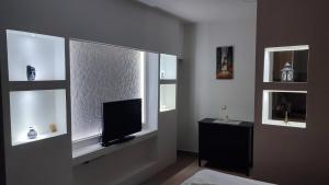 un soggiorno con TV e finestra di Airport Apartment AIR a Surčin