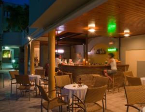 a restaurant with tables and chairs and a bar at Casa Maria Hotel Apts in Platanias