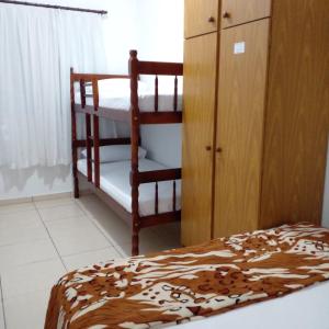 a bedroom with two bunk beds and a cabinet at Recanto Área Verde, tradição e cultura alemã in Pomerode +9 photos
