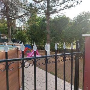 a black iron fence with a playground behind it at Γκρι βιλλα 2 in Periyiálion