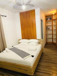 藻德濟的住宿－Moya Résidence by MD，一间卧室配有两张床和吊灯。
