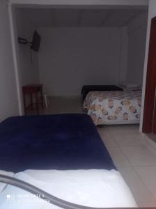 a bedroom with two beds and a chair in it at Hotel Las Palmas de Puente Nacional in Puente Nacional