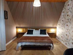 a bedroom with a large bed with two night stands at L'escale d'Armor in Loudéac