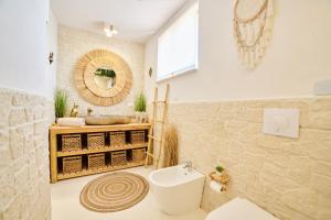 a bathroom with a sink and a toilet and a mirror at Design Sea Apartment -BOHO SUITE- Abruzzo in Francavilla al Mare +20 photos