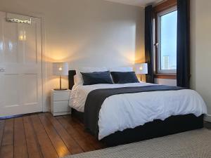 格拉斯哥的住宿－Large 3 Bed Apartment Glasgow West End Free Parking & Electric Vehicle point，一间卧室设有一张大床和一个窗户。