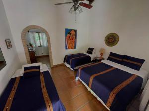 a bedroom with two beds and a ceiling fan at Hacienda La Esperanza in Copán Ruinas