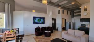 una sala de estar con un sofá y una mesa en Sanabl Druze Hospitality, en Ein Kinya