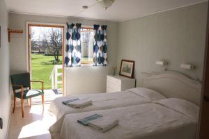 una camera da letto con un letto, una sedia e una finestra di Gula Hönan Guest House a Ronehamn