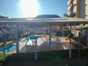 um gazebo com mesas e cadeiras ao lado de uma piscina em Caxias Thermas Hotel em Piratuba