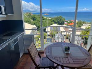 einen Balkon mit einem Tisch, Stühlen und Meerblick in der Unterkunft Appartement piscine et vue mer in Tartane