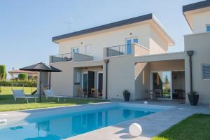 eine Villa mit einem Pool und einem Haus in der Unterkunft B&B Lough in Colà di Lazise