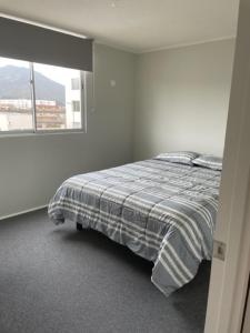 Habitación blanca con cama y ventana en Departamento Vista Aeropuerto, en La Serena