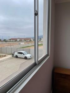 un'auto bianca è parcheggiata fuori da una finestra di Departamento Vista Aeropuerto a La Serena