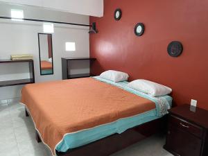 a bedroom with a bed with an orange wall at Sensity Home Preciosa y espaciosa casa todos los servicios 5 min del CIS in Tehuacán