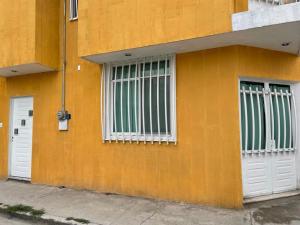 an orange building with white doors and windows at Sensity Home Preciosa y espaciosa casa todos los servicios 5 min del CIS in Tehuacán