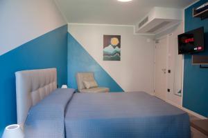 a blue bedroom with a bed and a chair at B&B Lough in Colà di Lazise +37 photos