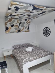 a bedroom with a bed with a camouflage blanket at River side suites in Belgrade