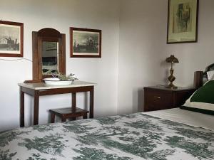 a bedroom with a bed and a table and a mirror at A casa di Tina in Mendicino