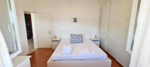 a white room with a bed and two windows at Sunset Apartments in Korčula