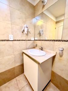 La salle de bains est pourvue d'un lavabo et d'un miroir. dans l'établissement Lumiere Apartments - Departamento en Complejo Residencial, à Mendoza
