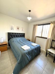a bedroom with a large bed with a blue blanket at Lumiere Apartments - Departamento en Complejo Residencial in Mendoza