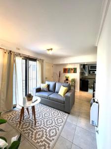 ein Wohnzimmer mit einem Sofa und einem Tisch in der Unterkunft Lumiere Apartments - Departamento en Complejo Residencial in Mendoza