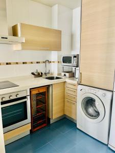 a kitchen with a washing machine and a washer at Luxury Pacifico Beach in Málaga