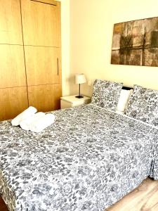 a bedroom with a bed with a black and white comforter at Luxury Pacifico Beach in Málaga