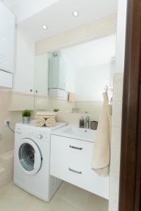 een witte wasruimte met een wasmachine en een wastafel bij Apartament Przy Starówce - Stella in Bolesławiec