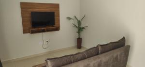 a living room with a couch and a tv at Casa Duplex Esperança - Ar e Garagem Privativa in Bom Jesus da Lapa