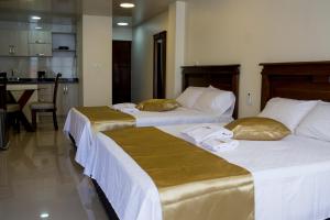 two beds sitting next to each other in a room at APARTAHOTEL LION in Tuluá
