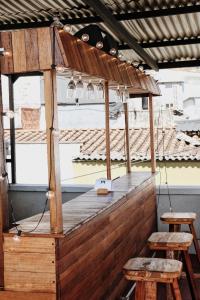 a wooden bar with two stools and two lights at La Familia Hostel in Medellín