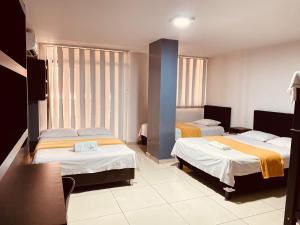 Postel nebo postele na pokoji v ubytování Hotel Escorial Ibagué