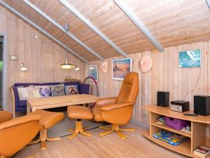 uma sala de estar com uma mesa e cadeiras e um sofá em 4 person holiday home in Oksb l em Øster Vrøgum