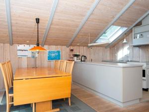 Øster Vrøgumにある4 person holiday home in Oksb lのキッチン(木製テーブル、カウンター付)