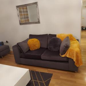 a black couch with pillows on it in a living room at Lovely 2-Bed Apartment in Milton Keynes in Milton Keynes